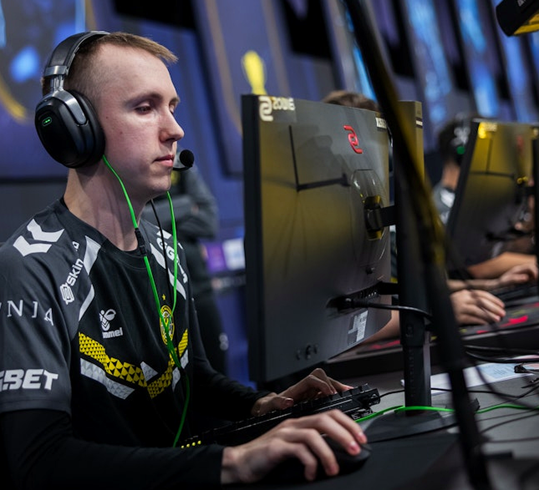 Игрок CS2 в гарнитуре на фоне символической защиты матча