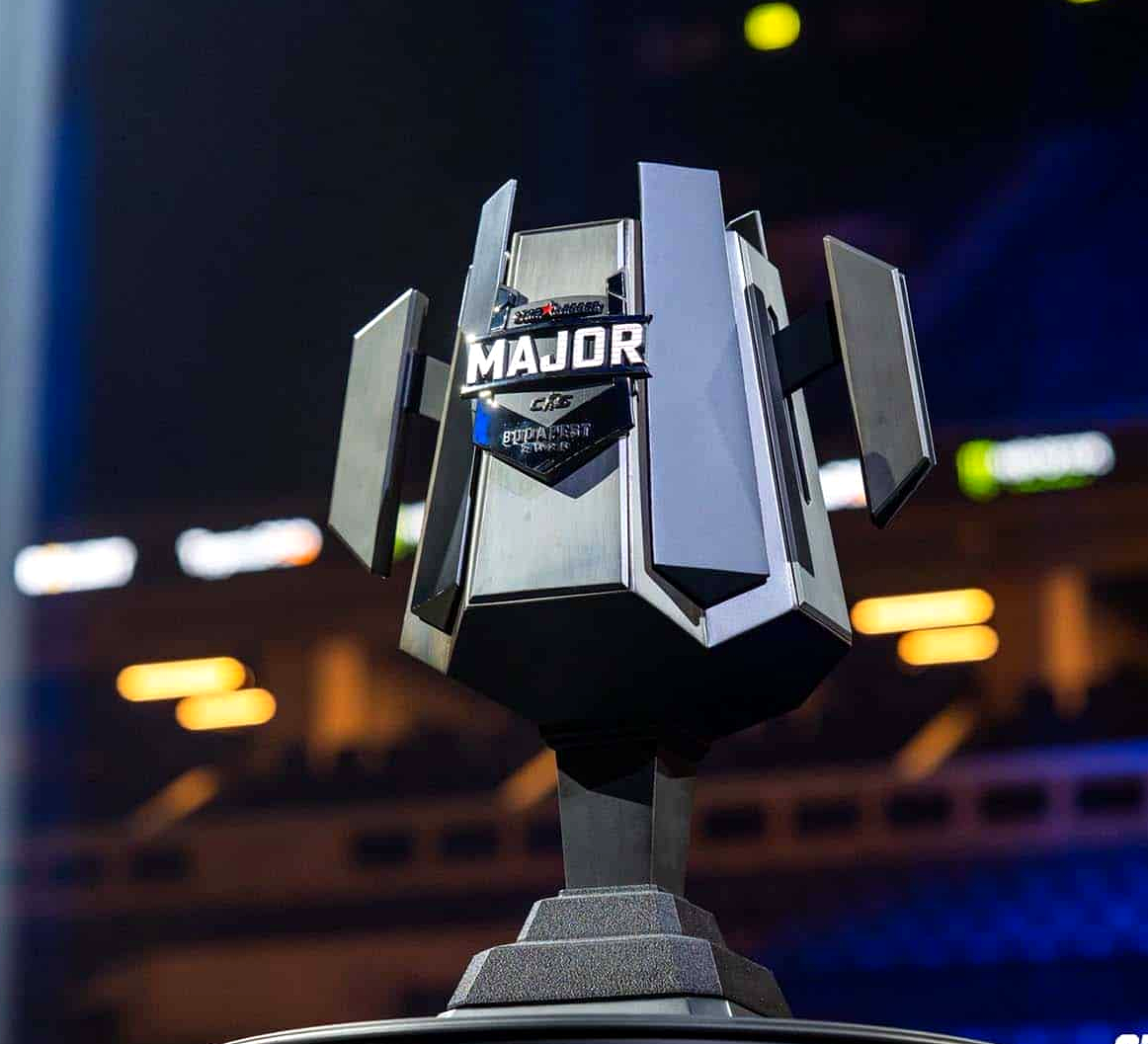 Трофей Major по Counter-Strike 2 на фоне арены в Сингапуре.