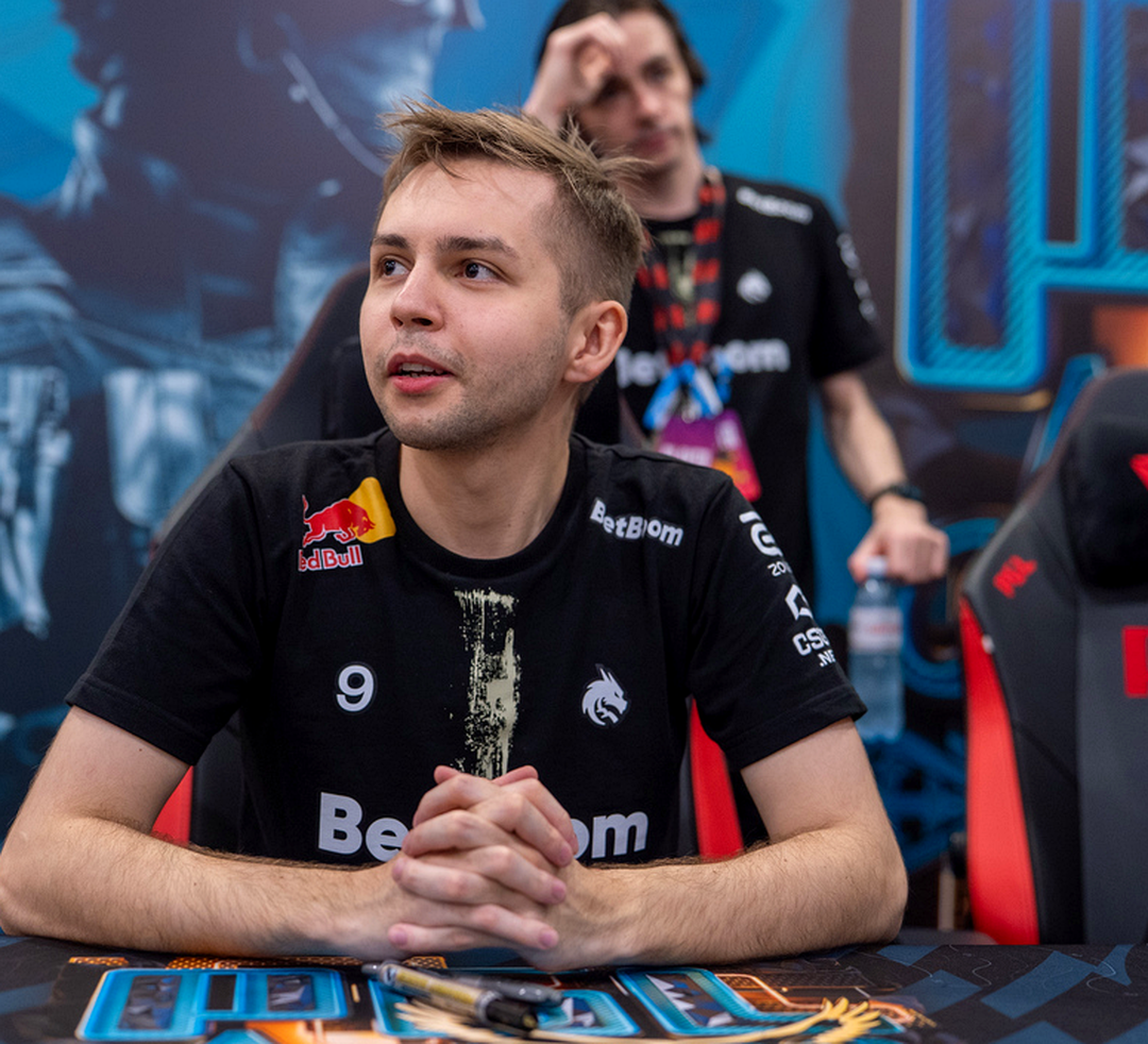 Игрок CS2 подписывает карточку с автографом для турнирной капсулы.